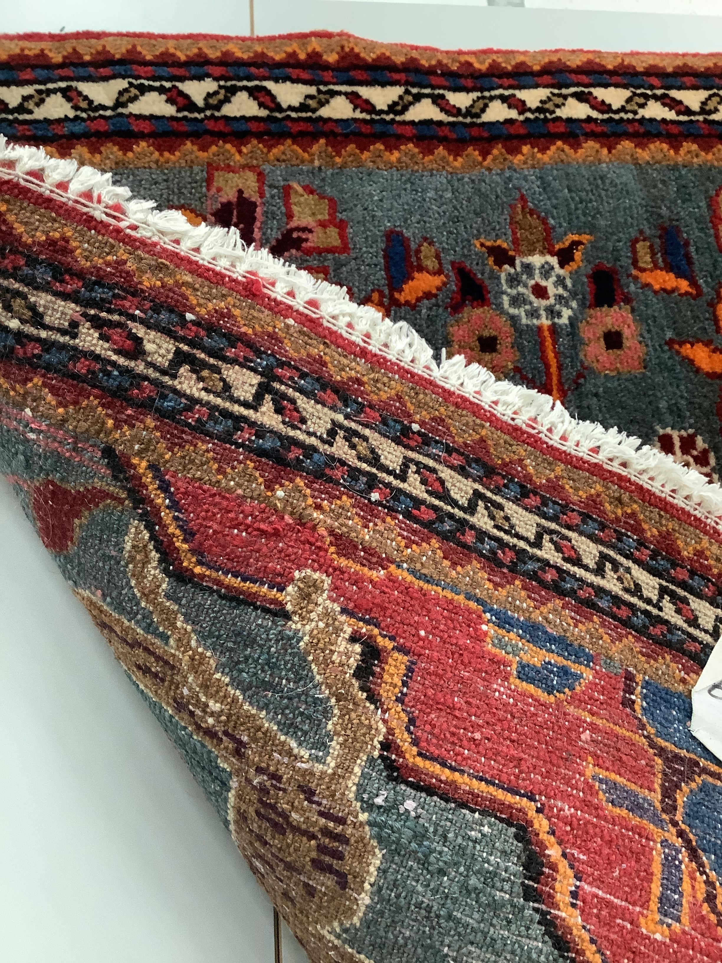 A Persian pictorial blue ground mat, 77 x 84cm